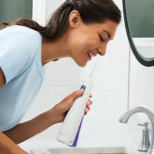 Woman using the WF-29 Waterpik Cordless 1000 water flosser
